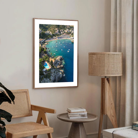 Drone photograph of a secluded Italian beach with boats drifting in crystal-clear water and steep cliffs in the background.