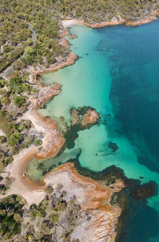 Aerial portrait of Honeymoon Bay Tasmania with turquoise waters and lush coastline.