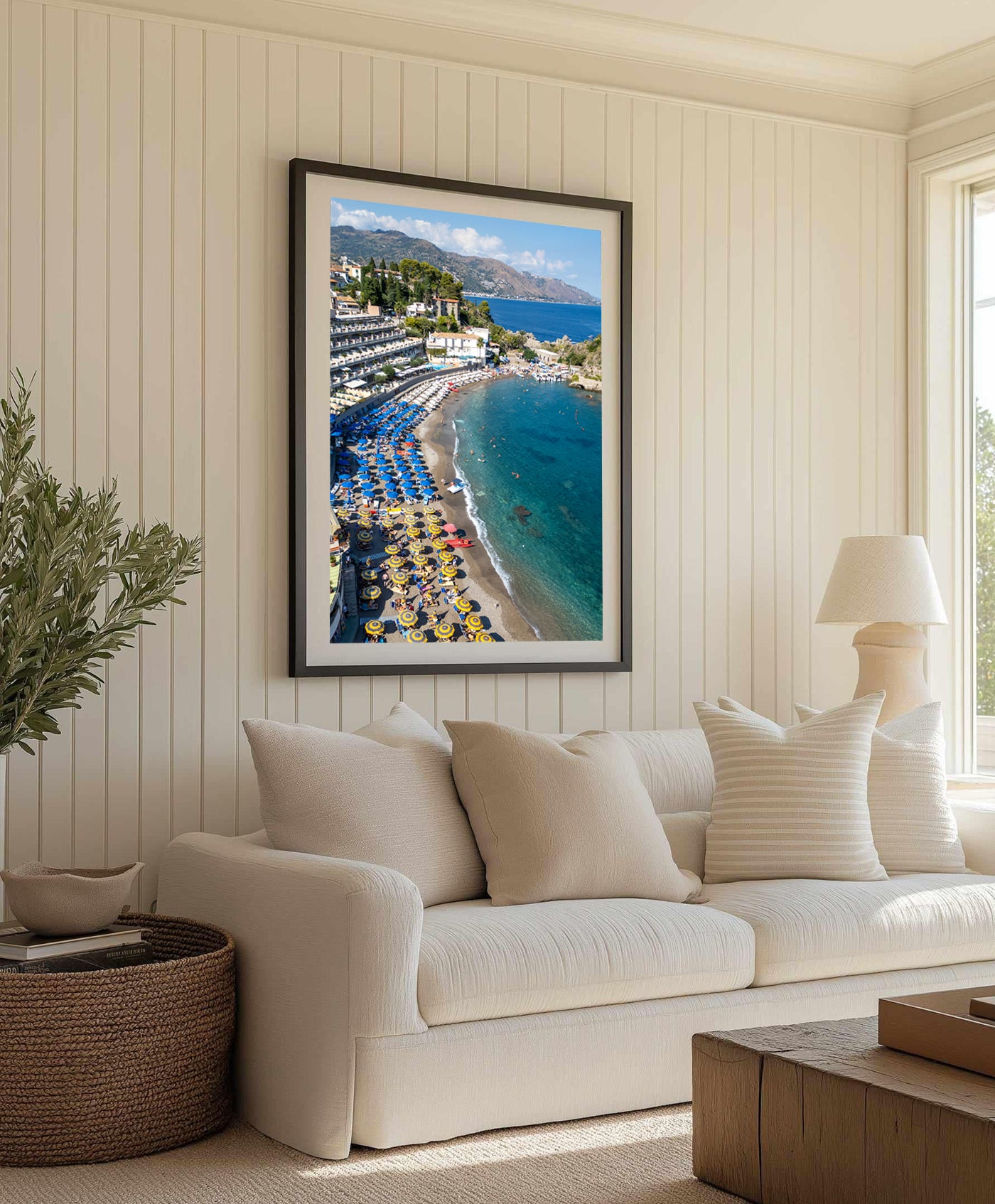 Drone shot of an Italian summer beach with umbrellas and beach chairs along the shoreline at Spiaggia di Mazzarò, Sicily