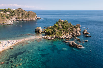 Aerial landscape image of Isola Bella Island off the coast of Taormina, Sicily, surrounded by turquoise Mediterranean water.