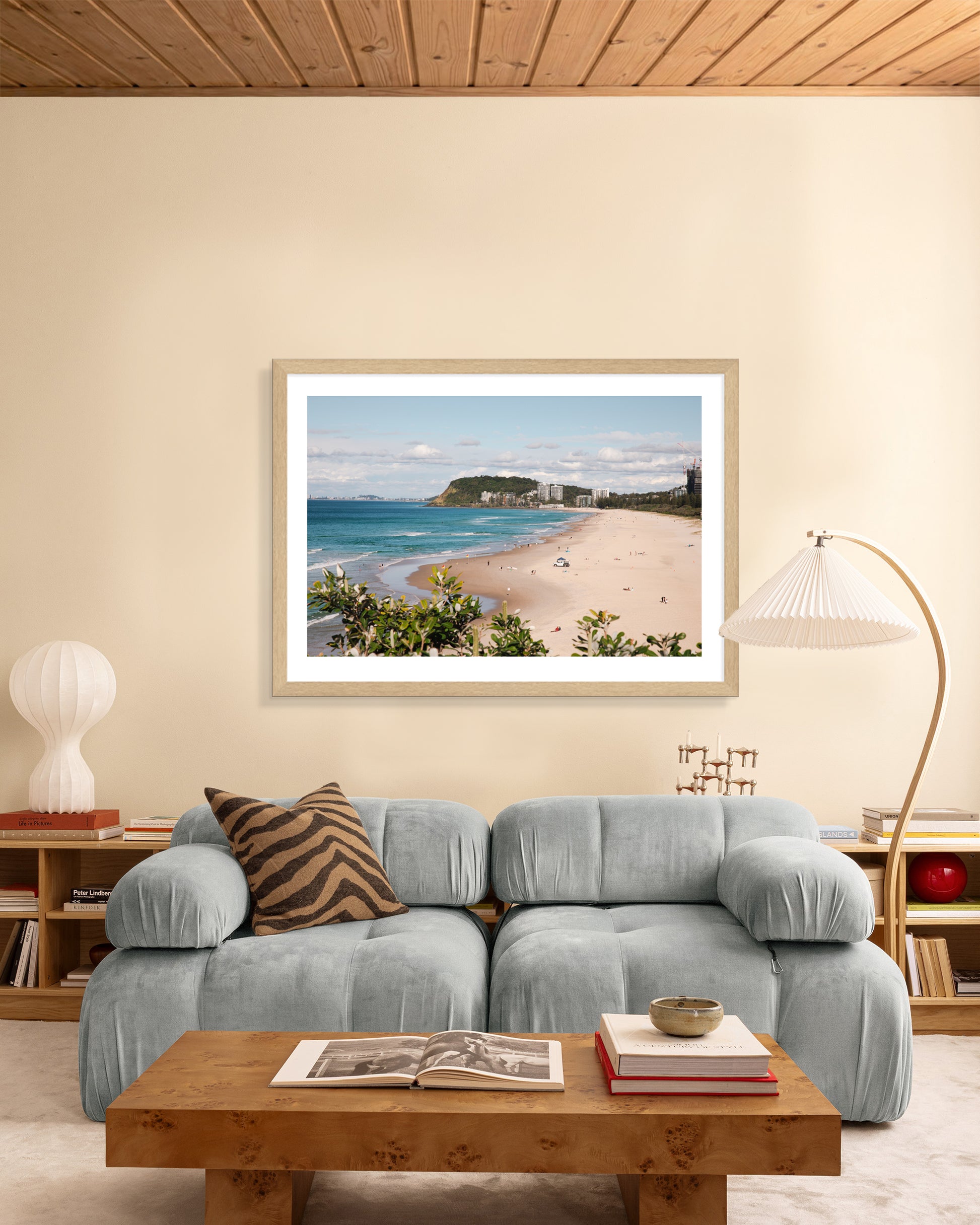 North Burleigh beach print in a natural oak frame styled in a living room