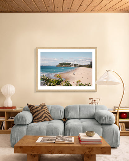 North Burleigh beach print in a natural oak frame styled in a living room