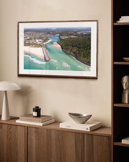Tallebudgera Creek aerial print in a dark walnut frame styled above a sideboard
