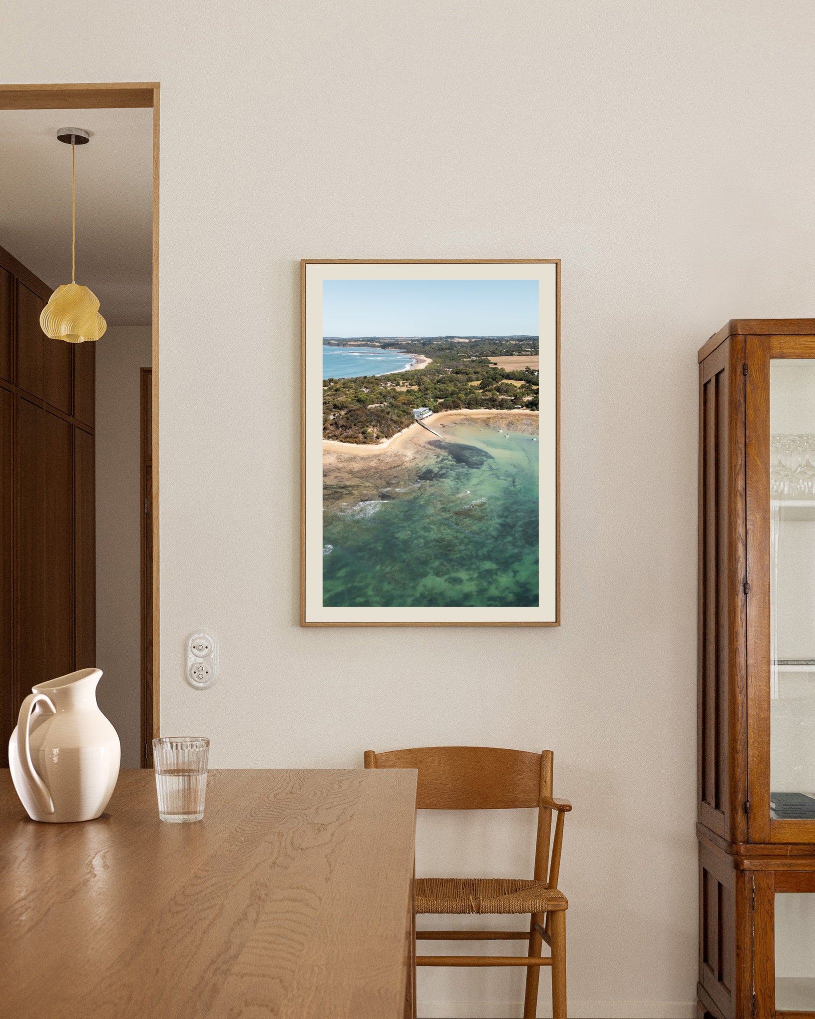 Point Leo Boat Club aerial print in a natural oak frame styled in a dining room