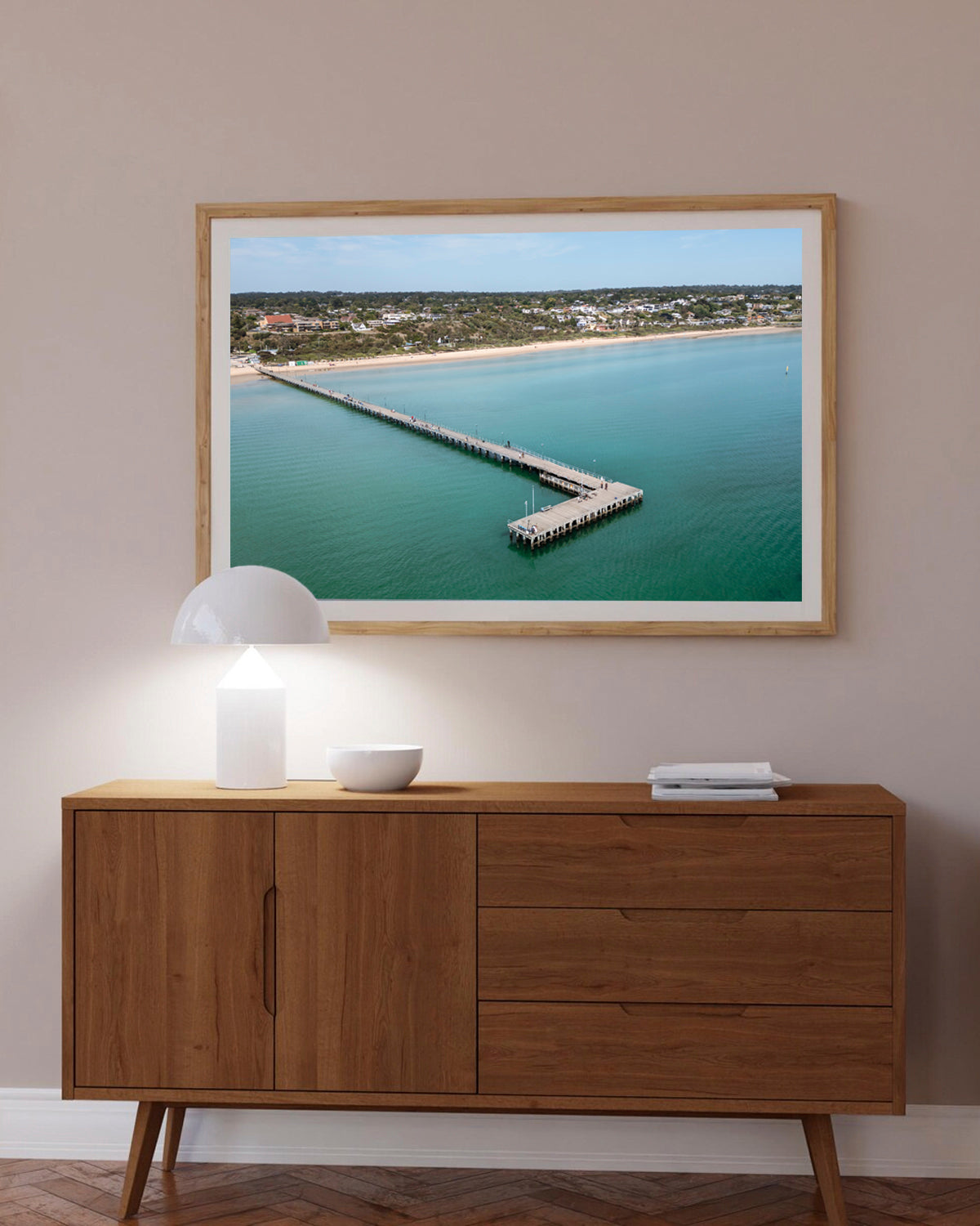 Frankston Pier aerial print in a natural oak frame styled above a sideboard