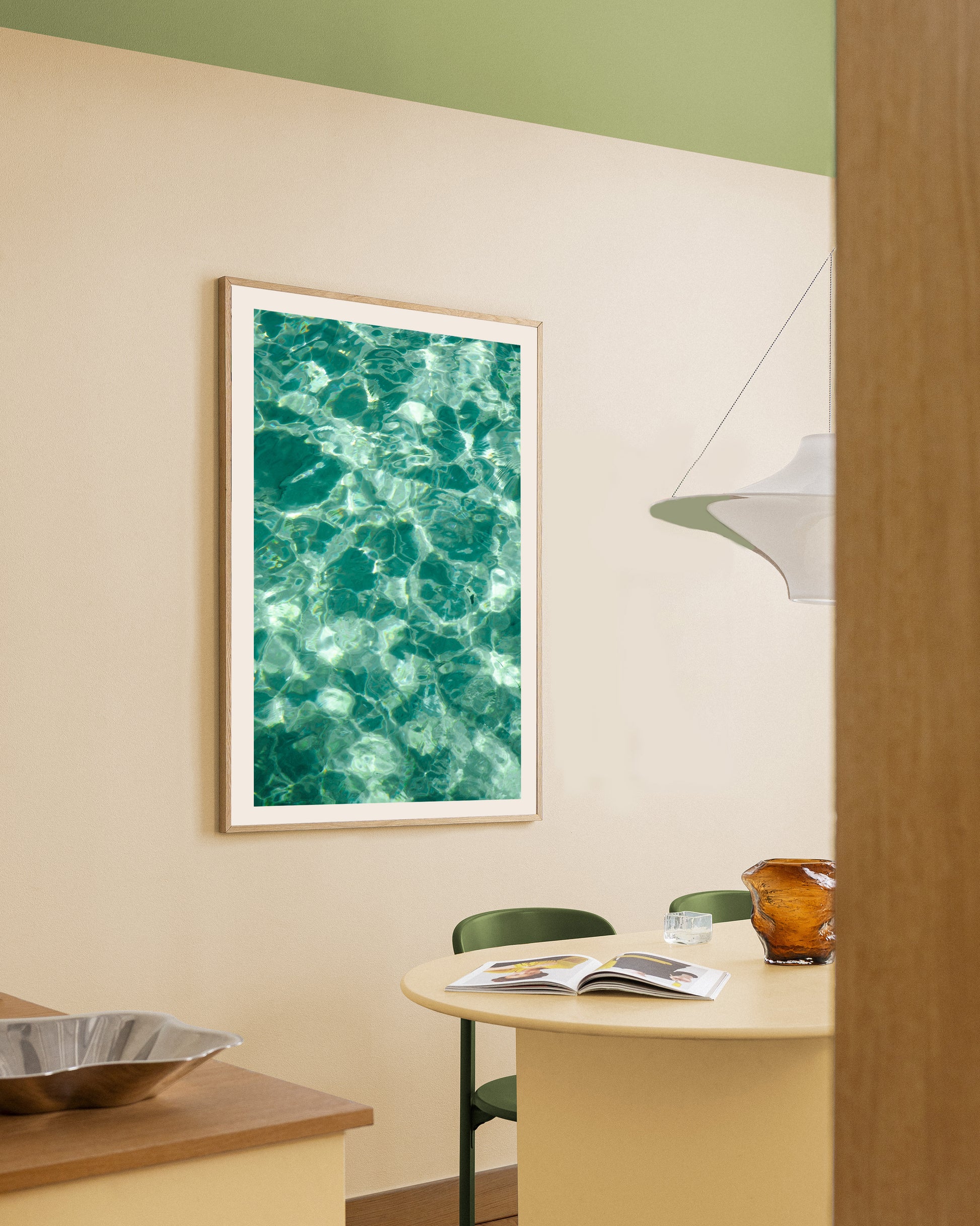 Turquoise waters abstract print in a natural oak frame styled in a dining nook