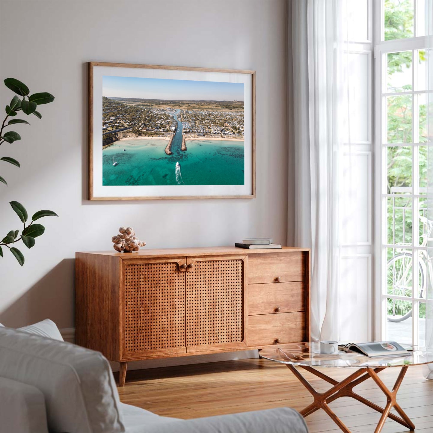 Safety Beach inlet aerial print in a natural oak frame styled above a sideboard