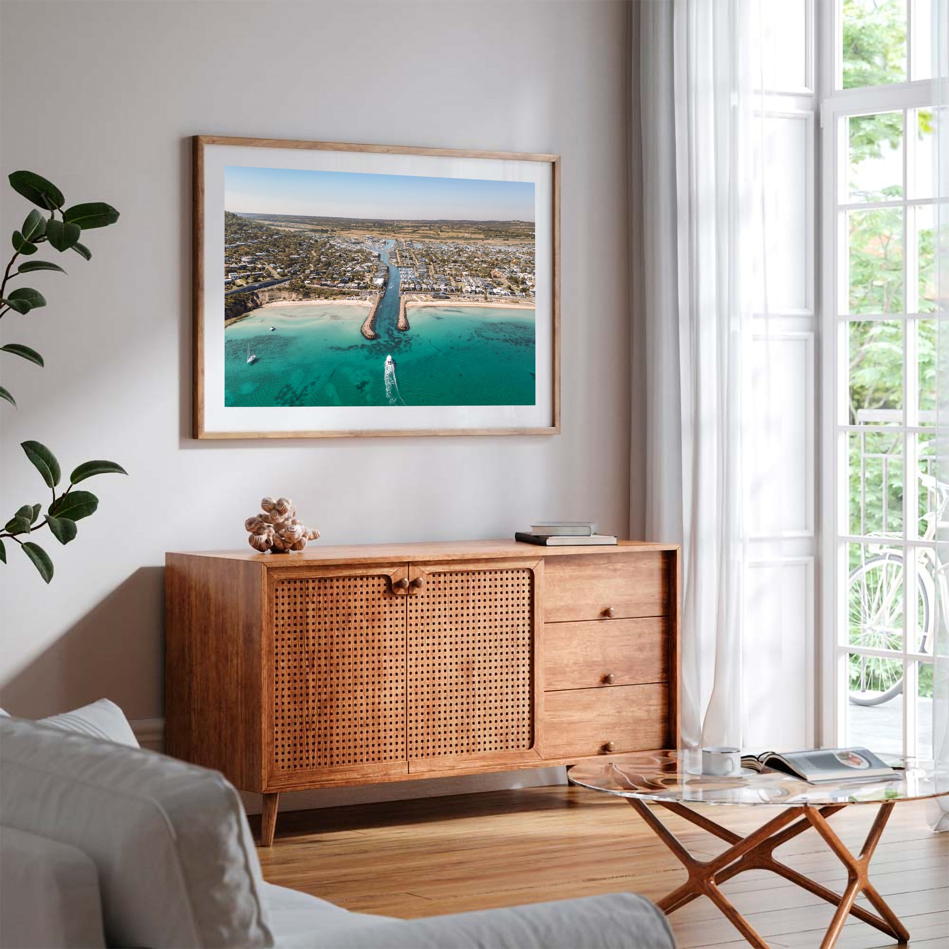 Safety Beach inlet aerial print in a natural oak frame styled above a sideboard