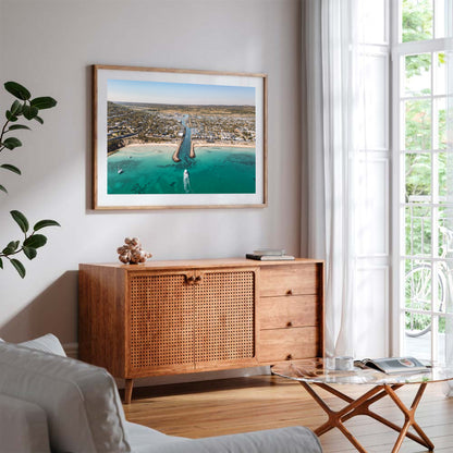 Safety Beach inlet aerial print in a natural oak frame styled above a sideboard