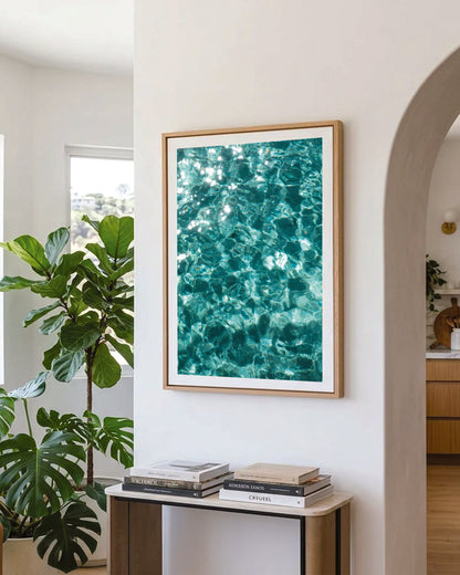 Crystal clear waters abstract print in a natural oak frame styled in a hallway