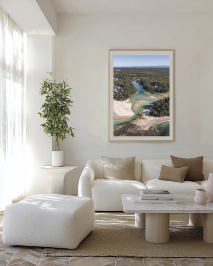 Moona Moona Creek print in a natural oak frame, styled above a cream boucle lounge with a marble coffee table.