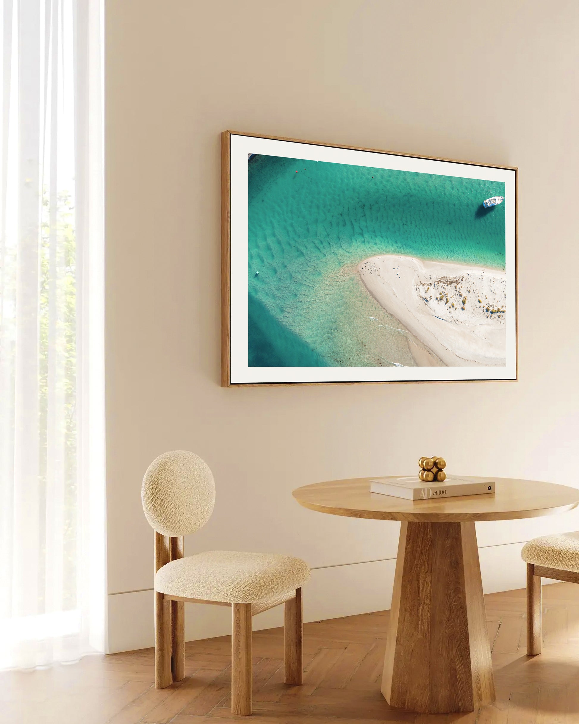 Myola Point print in a natural oak frame, styled in a dining nook above a round timber table.