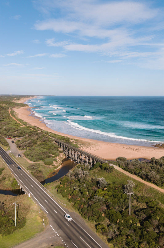 The historic timber trestle bridge at Kilcunda VIC crossing Bourne Creek, with the Bass Coast surf beach and ocean stretching behind.