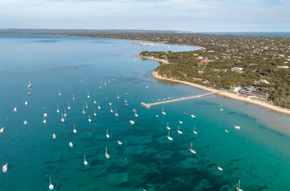 Aerial of Sorrento Front Beach on the Mornington Peninsula VIC, with boats moored on turquoise Port Phillip Bay and the coastline curving toward Blairgowrie.