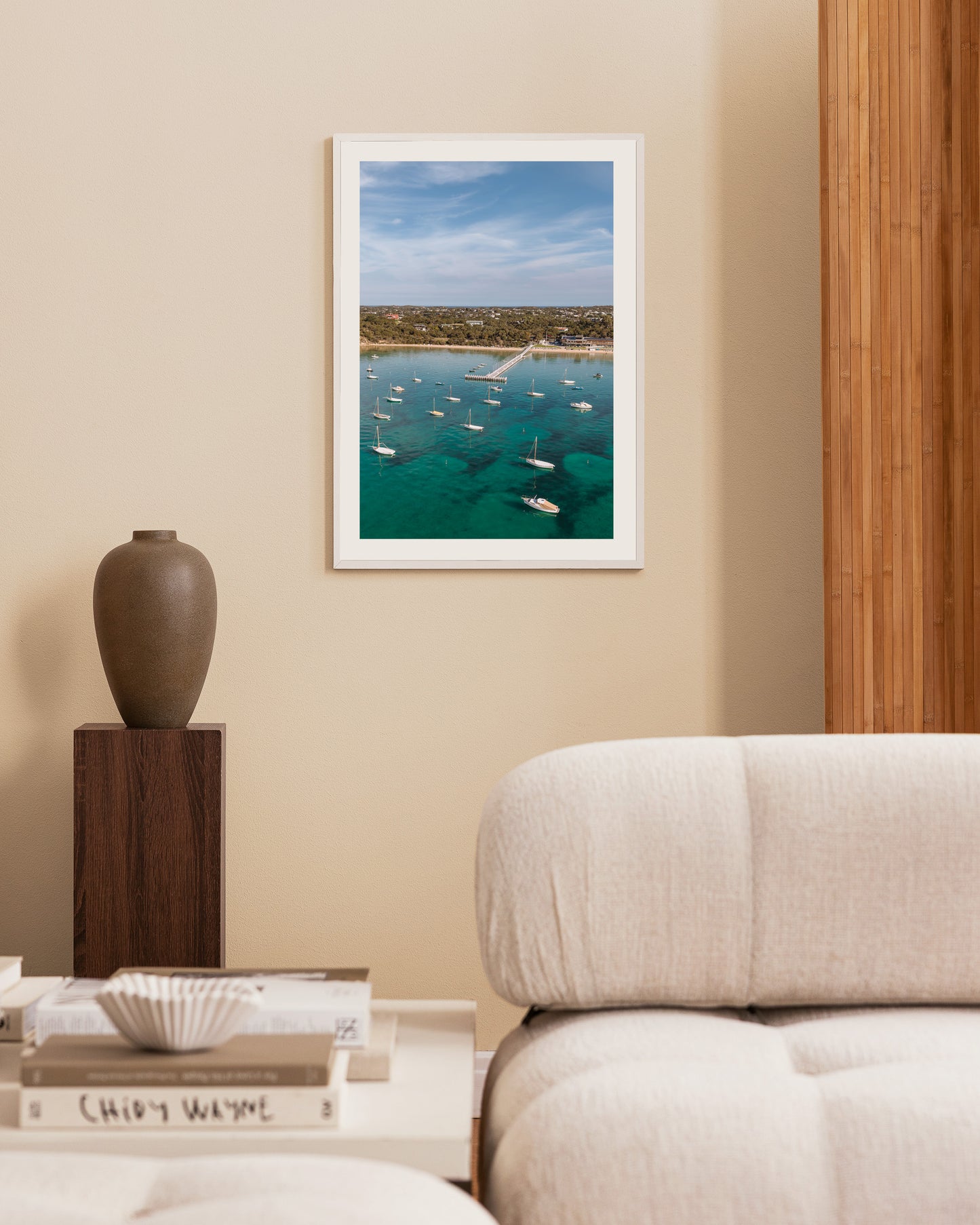 Sorrento Sailing Club portrait print in a white frame, styled beside a timber feature wall and dark ceramic vase.