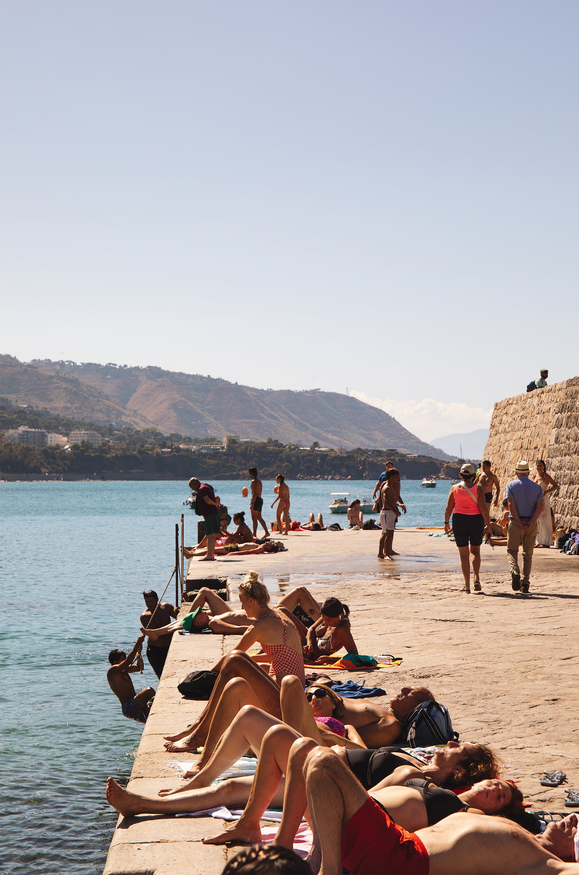 Jetée de Cefalù coastal photography print in Cefalù, Sicily, Italy, showing a summer scene on the jetty beside turquoise Mediterranean water.